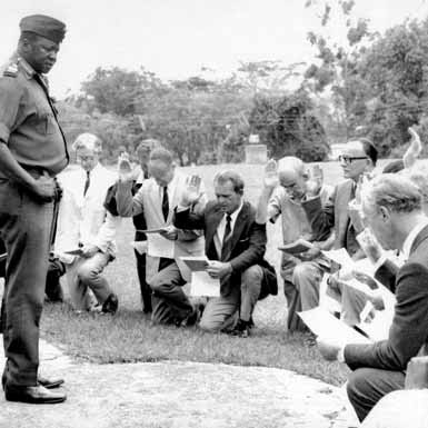 White diplomats bowing down to president Amin whilst reciting 'Oath of Allegiance' to him as a ruler of Uganda